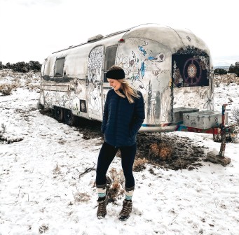 Kay standing in snow outside of an airstream in the Grand Canyon